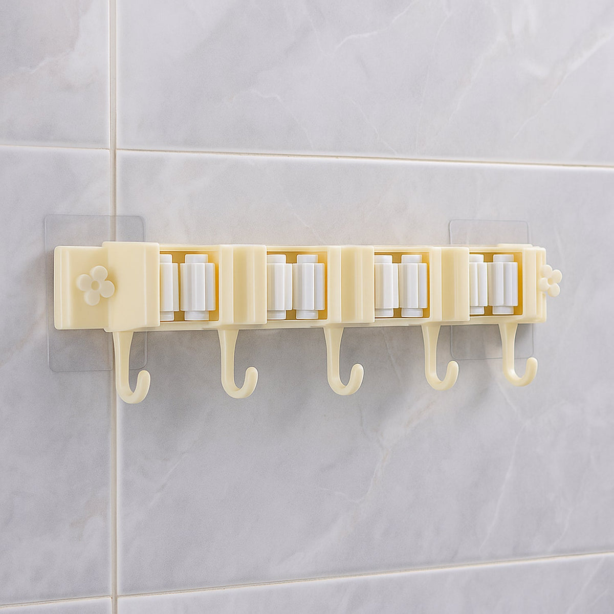 Self-adhesive broom and mop holder rack mounted on wall with utility hooks